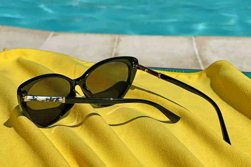 Occhiali da sole su telo mare giallo a bordo piscina, ottimi regali gadget personalizzabili per l'estate | Fullgadgets